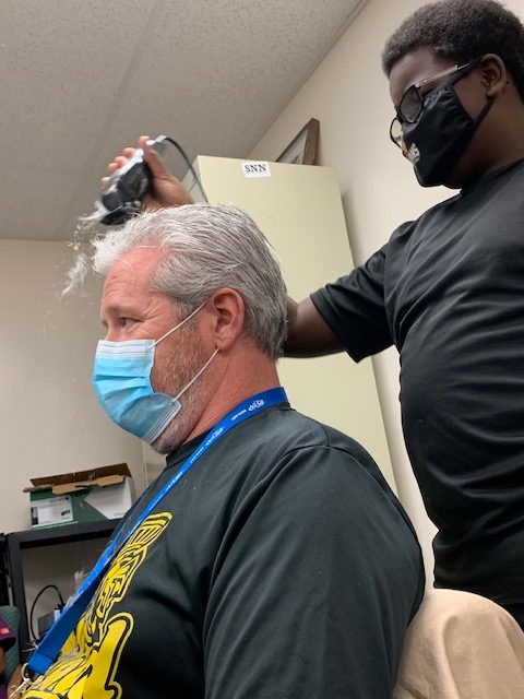 Freshman Adrian Lovett shaves the hair off teacher Michael Dolhancryk ‘s head in November in VE
specialist Emily Cipolla’s office.