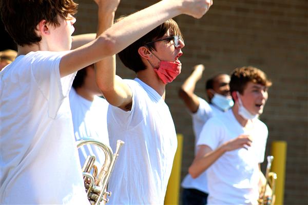 French horn player Gavin Bradley chants with the band Oct.15 during its first performance of the year in the bus circle.
