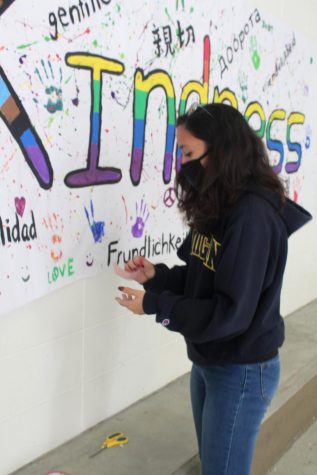 Senior Casey Miltner helps tape 
a kindness poster in the Hub 
on Feb. 16. The National Honor 
Society also passed out candy.