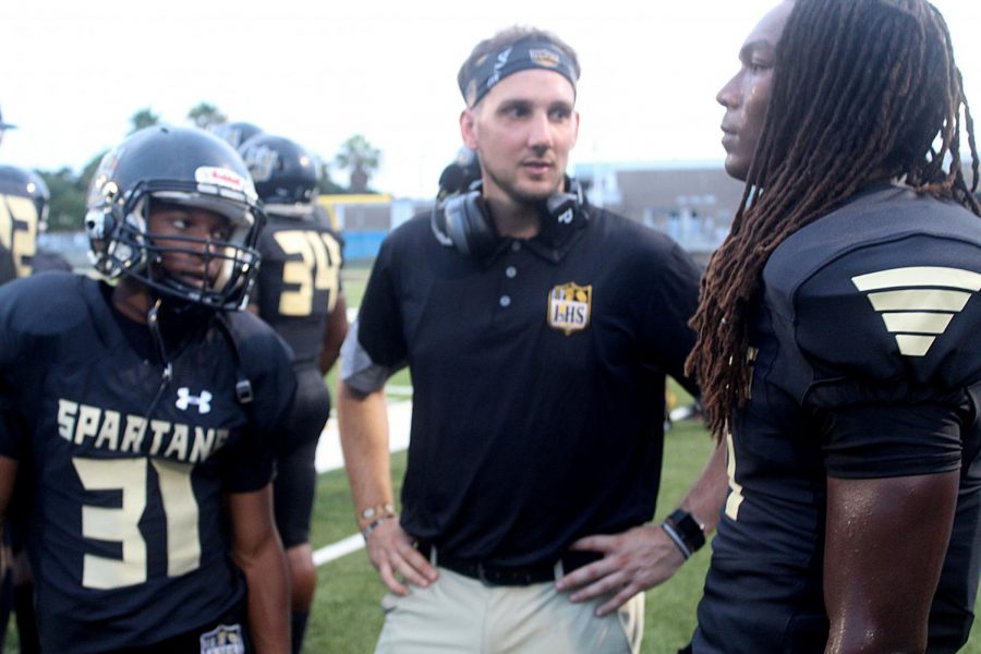 From left, sophomore Tyrell Bell, coach Phillip Muszynski and senior Camari Berry talk on the sidelines during a game against Atlantic on Sept. 17.