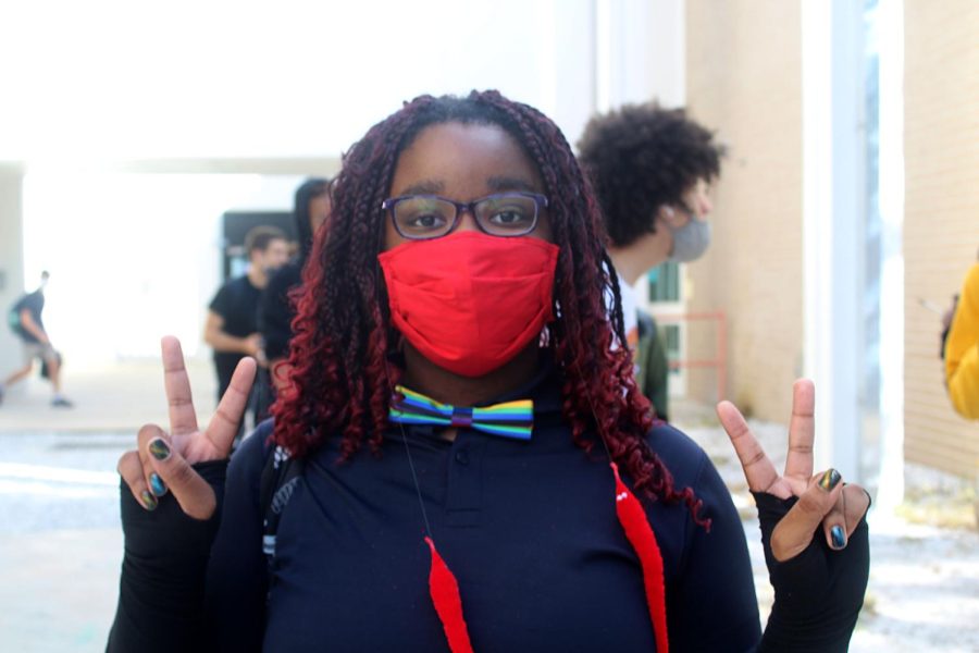 Senior Ace Williams poses with peace signs sporting red on Class Color Day between A and B wing on Oct.6 