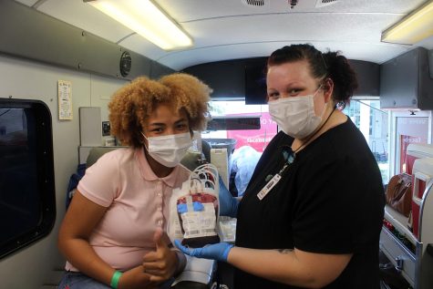 Junior Falicity Ozuna poses with nurse Jordan Lewis with her pint of blood on Sept. 21. Many students will donate blood because to help a close friend or family memeber. My cousin has sickle cell so thats why Im donating. It feels great, Ozuna said. 