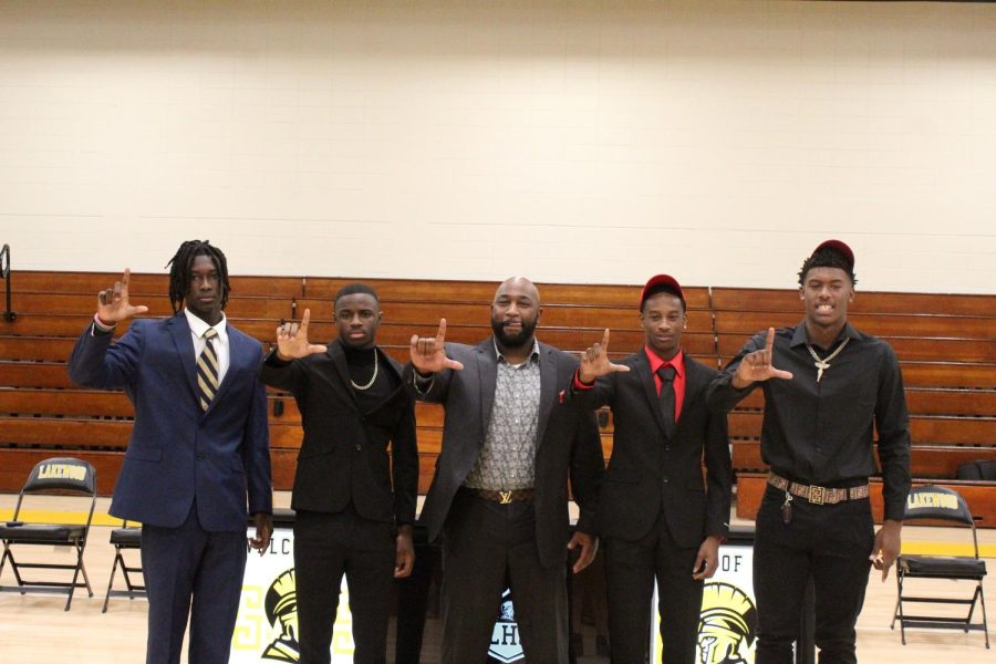 From left, Emmanuel McNeil-Warren, Terrell Crosby, head football coach Cory Moore, Mike Evans and Amari Niblack hold up the 
