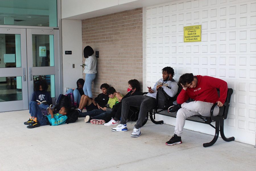 A group of students wait for their late bus in front of Lakewood High School on Dec. 1. Many of the buses have been showing up late to pick kids up in the afternoon.  It annoying, inconvenient and unsafe for the bus to be an hour late all the time, Shaimya Mitchell said. 