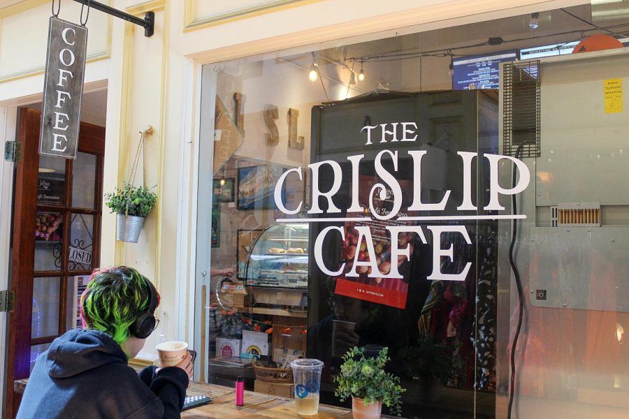 A patron of the Crislip Cafe drinks coffee, talks on the phone and draws in a notebook on Nov. 7, 2021. The café is on Central Avenue in St. Petersburg. 