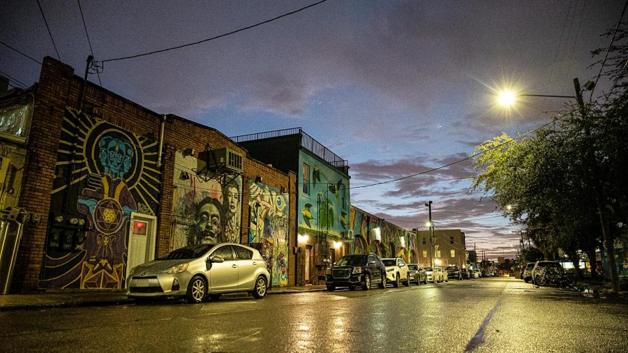 Streetlights shine on a wet pavement in downtown St. Petersburg. Each year as part of the Sunshine Mural Festival, artists paint murals across the city.