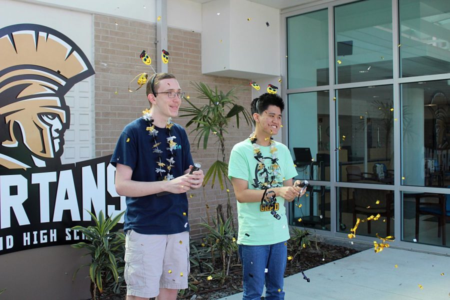 From left, Jackson Culbreth and Brian Tran shoot conefetti poppers in front of Lakewood High School on Friday (2/25). Tran was named Center for Advanced Technologies valedictorian while Culbreth was named CAT salutatorian.
