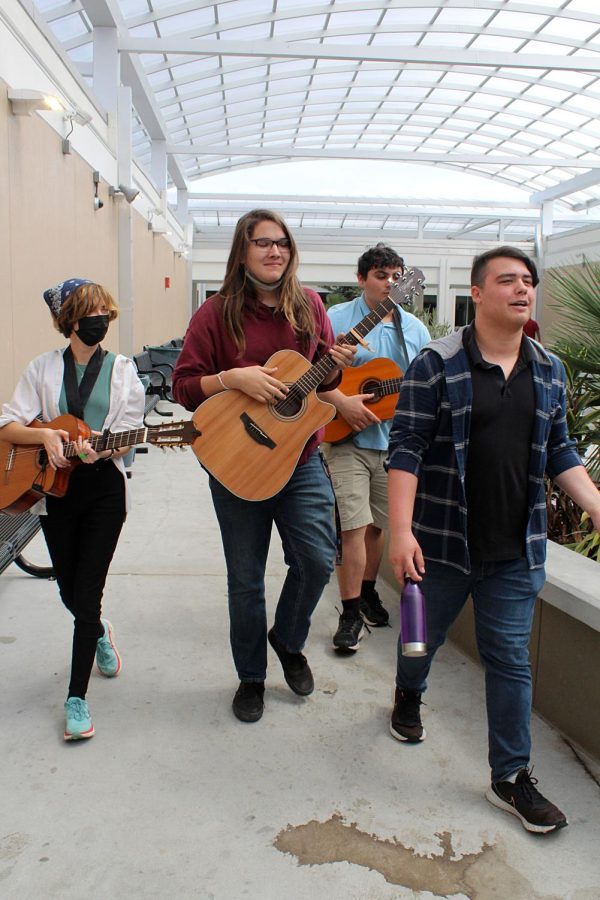 From left juniors Bella Croteau, Xander Riddick, Steven Chisari and senior Jordan Alcira walk through The Hub on March 9. The group played Cherry Wine by Hozier. My favorite part about playing in front of classes was their reactions were unexpectedly positive, Croteau said.  