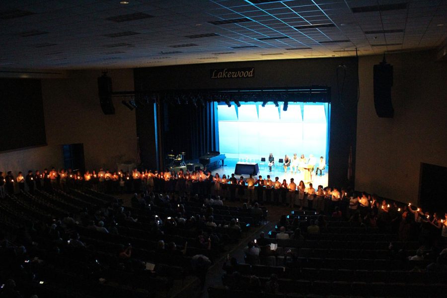 The new National Honors Society inductees stand in front of the stage in the main auditorium on March 3. NHS sponsor Heather Robinson couldnt hold the ceremony earlier in the year because of construction. I Loved just seEing the families together and seeing the kids holding their candles, that was a really special part, and then being able to celebrate all together, Robinson said. 