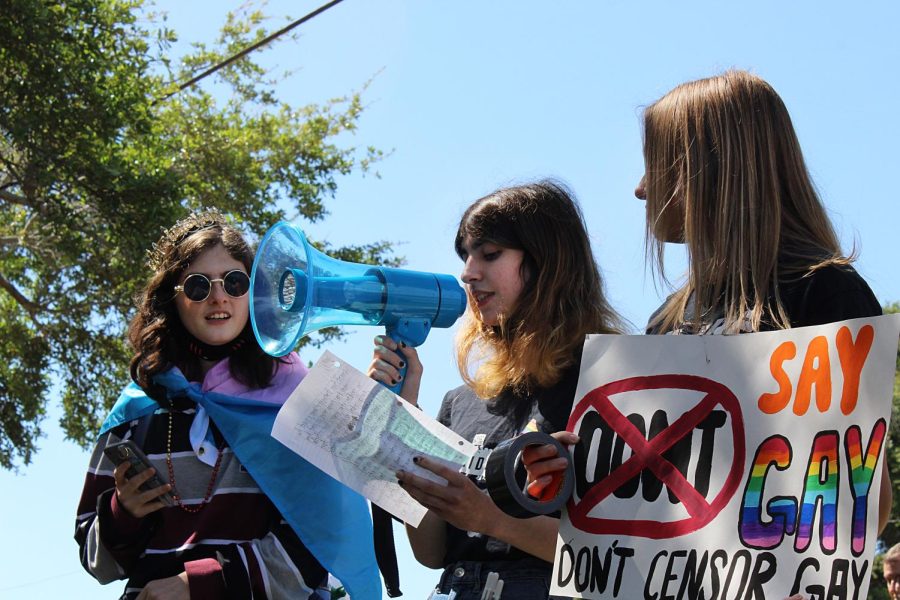 Senior Iris Pupo, center, speaks through a megaphone to a crowd of protesters at the LGBTQ walkout on March 3 in front of Lakewood High School. At left is senior Jack Land at right is junior Nicole Bundy who organized the peaceful protest. 