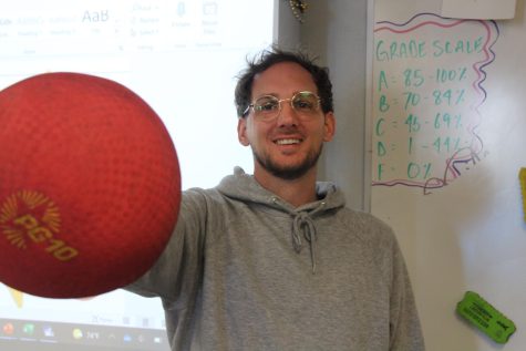 Science teacher Phillip Muszysnki holds up a kickball in his classroom on April 2. Muszynski is in charge of the staff vs. students kickball game. Every year we get trash talk privileges. Its just a fun event, Muszynski said.