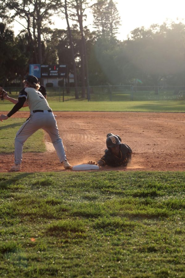 Junior Ryan Morrow slides back to first base during their first playoff game against the St. Petersburg Catholic Barons on May 2.