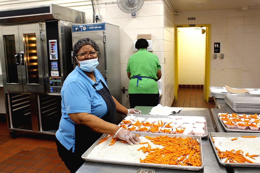 Cafeteria worker Velma Walker places sweet potato fries into small containers on April 5 on the prepping station in the back of the cafeteria. Walker is doing this to prepare the fries to be served during lunchtime. Prepping fries usually takes 20 to 30 mintues since its already frozen so it doesnt really take long to make, Walker said.