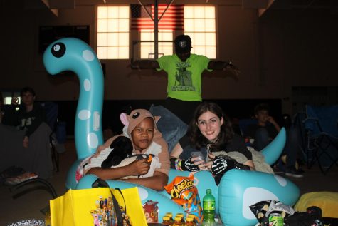 From left, seniors Jay Sanders, Demetrius Henry and Jack Land lie on a pool float with Henry above them at movie night during senior week on April 26 in the gym. 