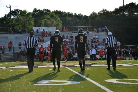 From left, seniors  Khire Butler and Samorion Lang walk out for the coin flip before the game Aug. 19 on the Lakewood High School football field.