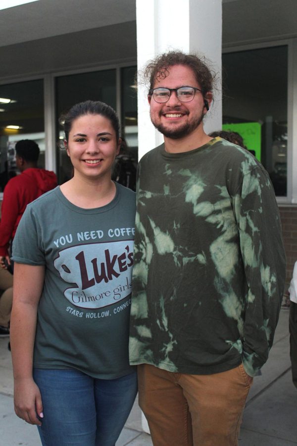 From left to right Senior Katelyn Barnes and Senior Angel Anderson pose in the homecoming tickets line on Sept. 21. Both of these students are wearing green for the SAVE Promise clubs Say Hello Week. This week is meant for building connections, putting a stop to bullying, and ultimately building a community.