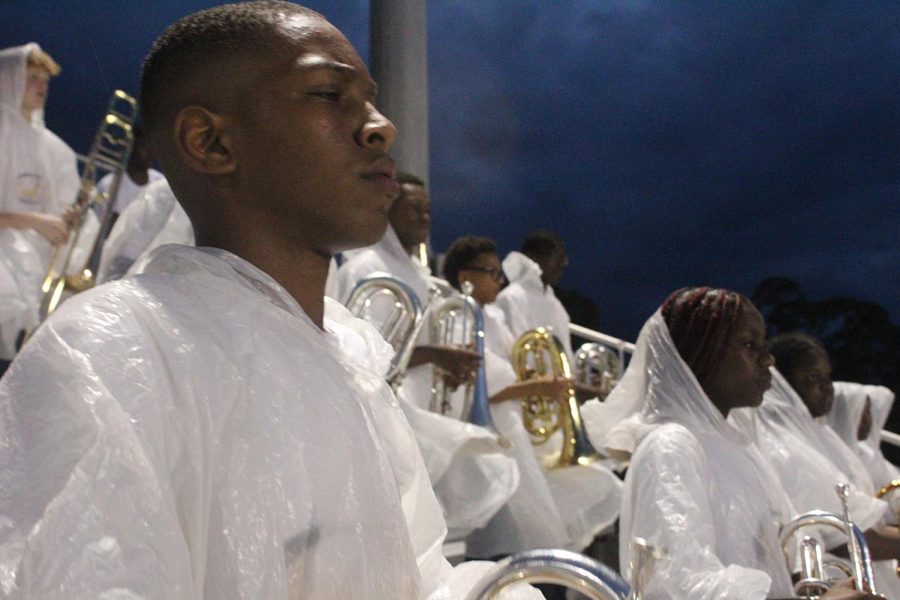 Junior Micheal Davis wait for the instructions from band teacher Damien Lyles, during the the rainy weather.