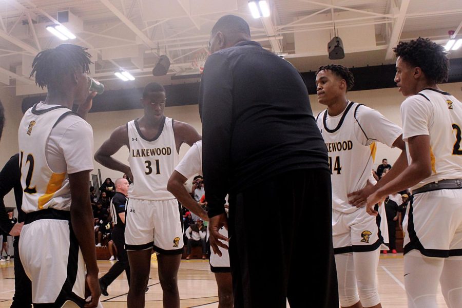 Senior Chamberlain Campbell joins in a huddle to listen to coach Anthony Lawerence on the sidelines during a game St. Pete High Schoool on Dec. 9.
