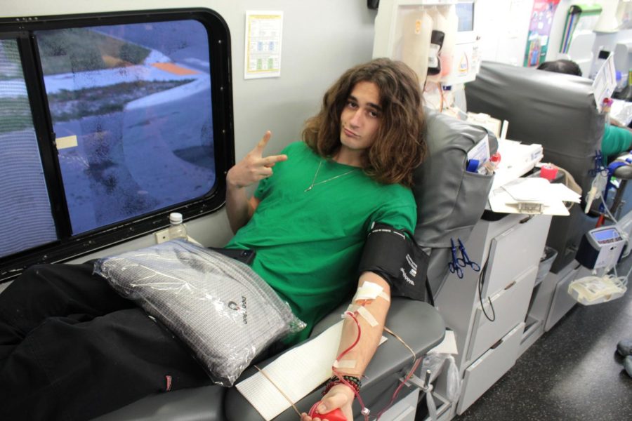 Junior Domanik Kraemer donates blood at Lakewood High School on Dec. 1. This is Kraemers first time donating. I give blood because it helps but I really want the free snacks, Kraemer said.