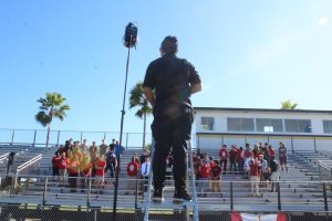 A Lifetouch photographer stands on a ladder to take the CAT senior photo during club picture day 2019. This year's club picture day is Jan. 24 in the gym.