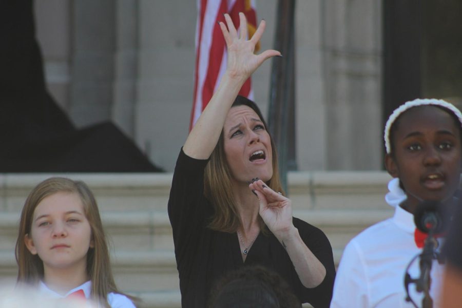 ASL interpreter signs the flares in the sky during the national anthem sung by Bay Point Elementary chorus on Jan. 30.