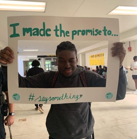 Senior Ciretee Carter poses with a SAVE Promise Club sign on March 29 for Start With Hello Week.  