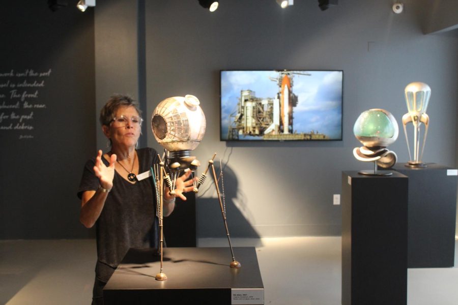 Docent Amy Howell explains the process in which glass art is made at the Imagine Musuem on March 30. This particular artist based their work on spaceships and other aeronautical themes. 