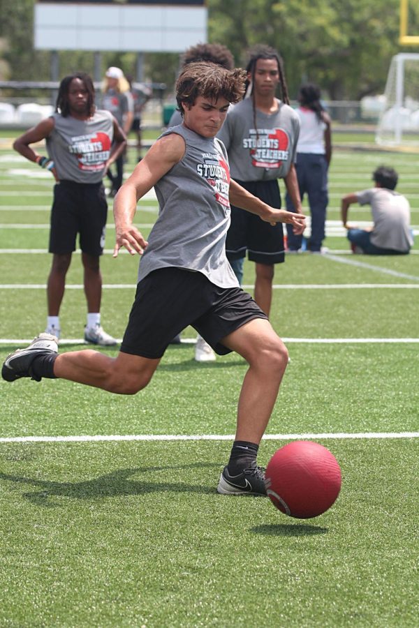 Sophomore Eli Largent kicks a kickball during a student kickball game on April 23rd. The games were played to promote physical health at the school. 