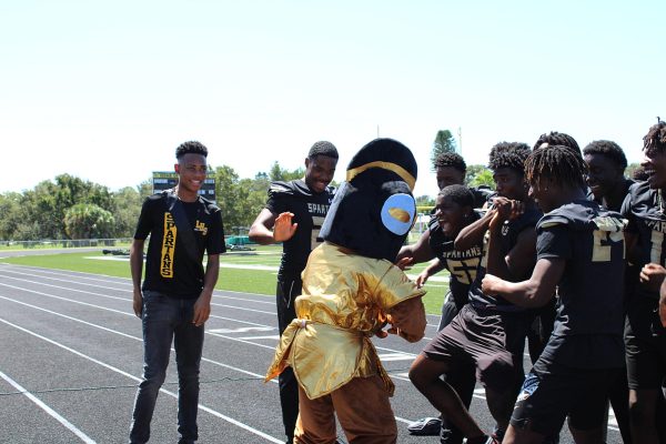 Spartans mascot dances with players of the football team during the powderpuff game. 