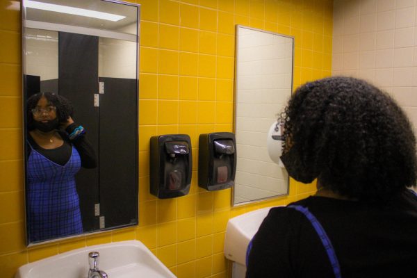 In the A Wing bathroom sophomore Blessing McCants looks at herself in the mirror on Dec.5. Getting dress coded made me feel like since by body was different, I couldnt dress like other people, McCants said.