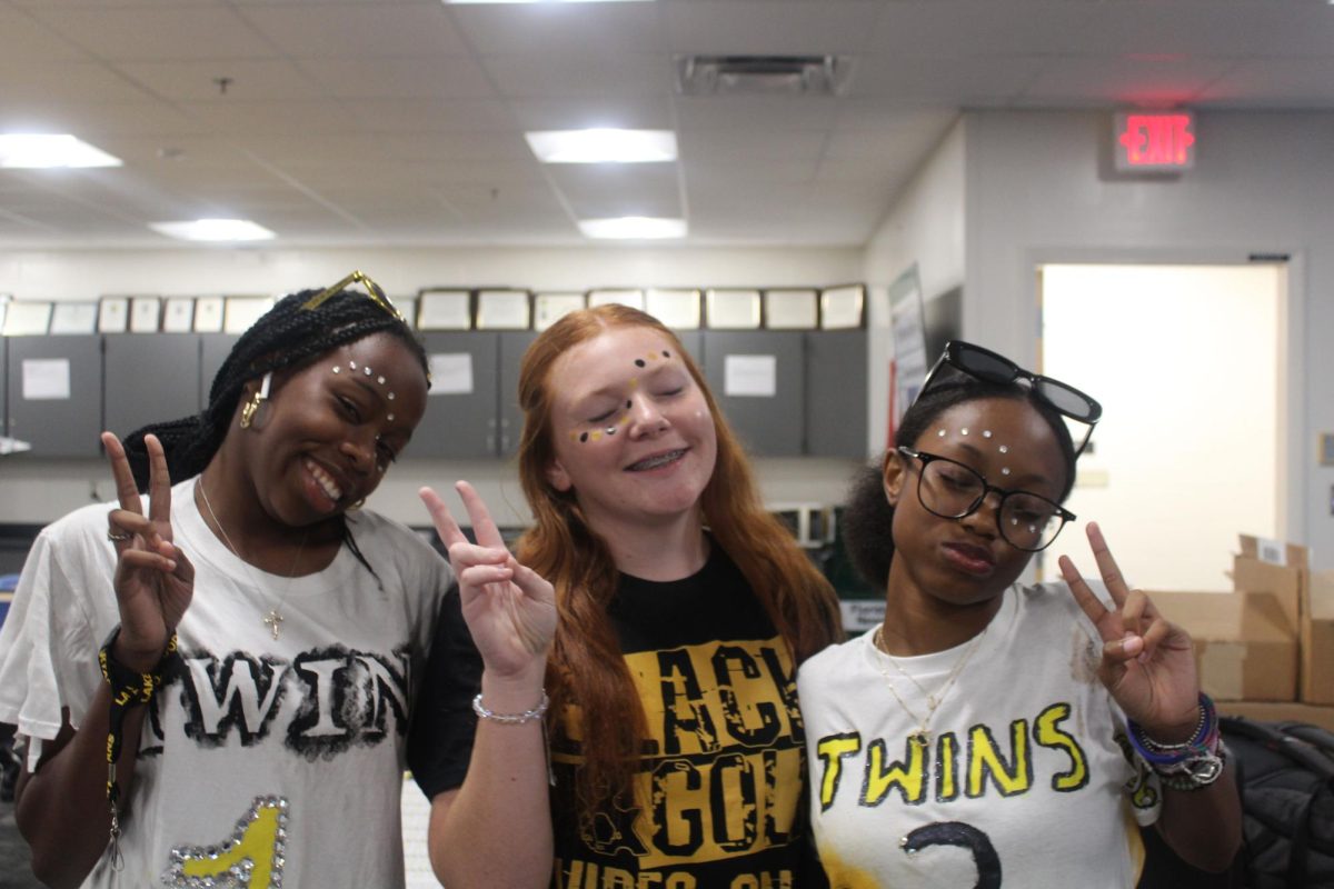 Students posed for the camera wearing facepaint in the school colors. Wearing black and gold is one way to show school spirit during spirit week.
