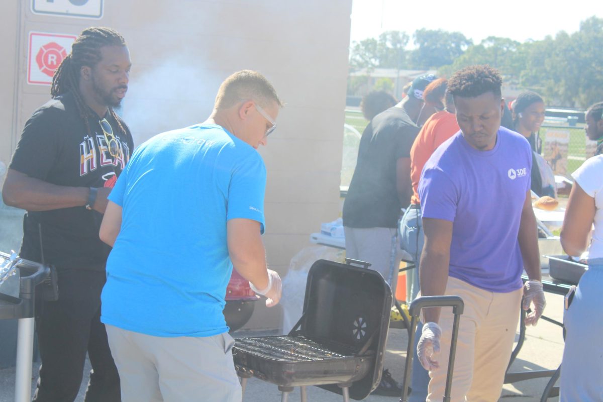 Computer Science Teacher Christopher Borg works the grill next to Lakewoods Football field on Nov. 30th. He is doing this to help celebrate Lakewoods first Thanksgiving Cookout. 