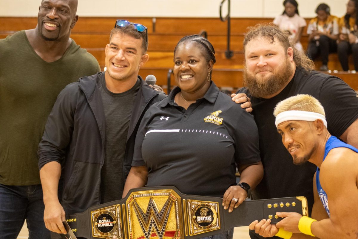 Alpha Academy members Otis, Akria Tozawa, Chad Gable and Maxxine Dupri, stand with Professional Wrestler Titus ONeil hold the WWE belt with Lakewood High School Principal Connisheia Garcia on Jan.27 in the Lakewood High School gym. WWE came to Lakewood High School and donated 15,000 dollars.