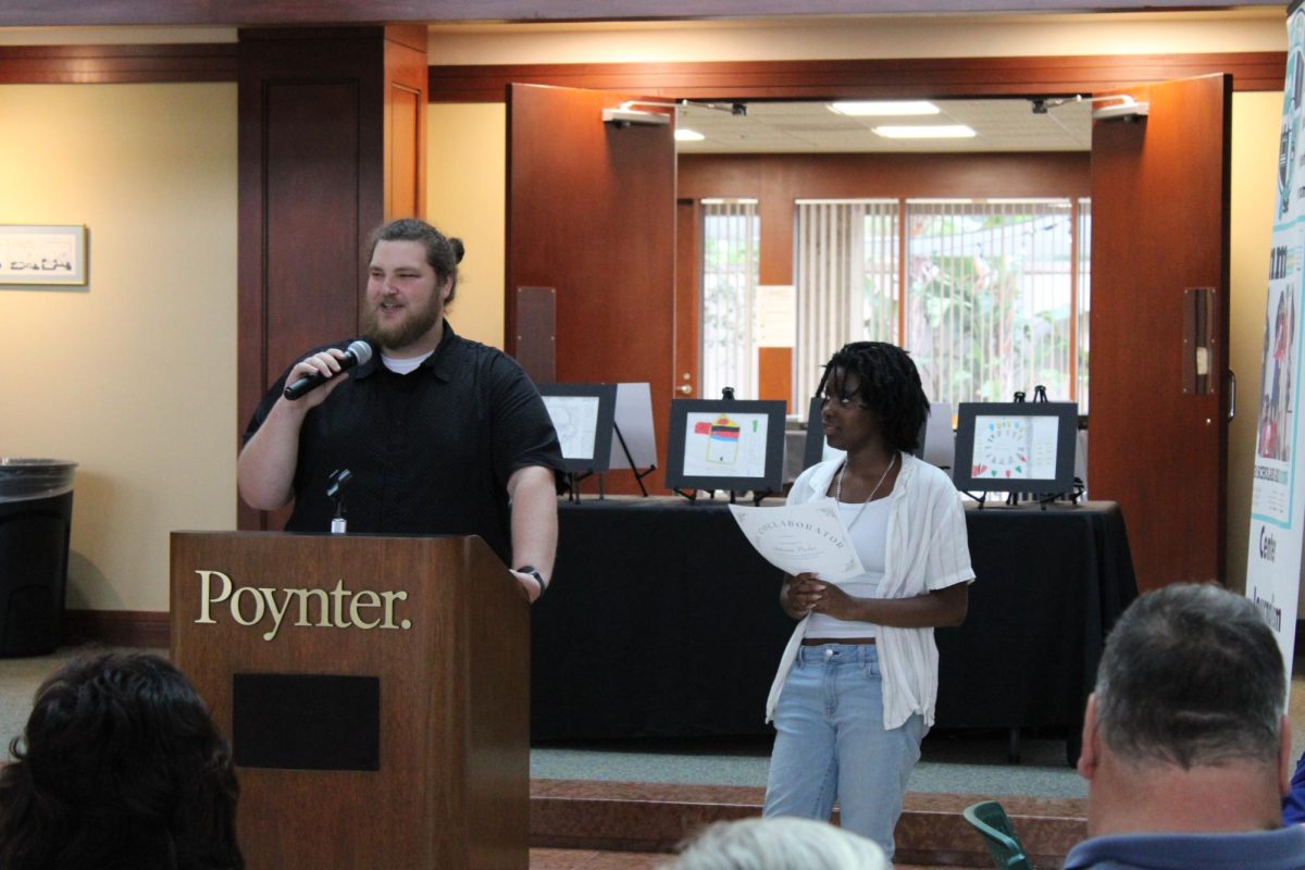 Senior and Editor In-Chief Autumn Peelar accepts award from journalism teacher Christopher Mosher at the Poynter Institute on May 9. 