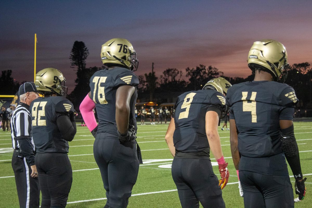 Captains Lionel D Wilson, Chancellor Campbell, Logan Houck, and Keontae Byas wait on the sidelines for the coin toss to commence for Lakewood's homecoming game.