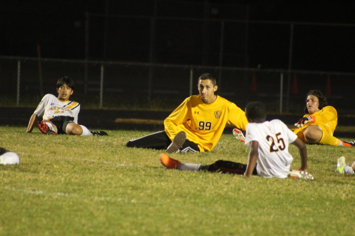 Coach Matthew Cortez stretches with the whole team to ensure there are no injuries during the game.