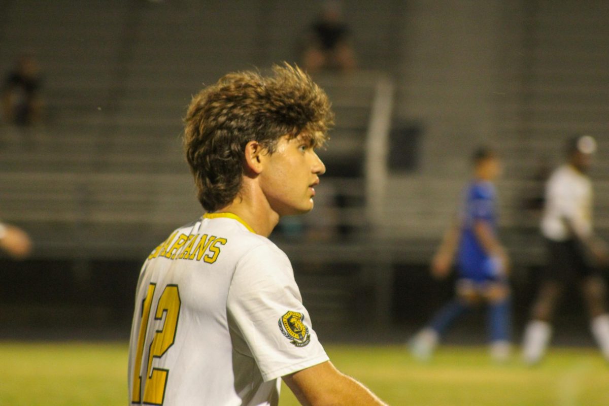 Senior Lucas Hicks walks down the field to pass the ball to his teammates at the Osceola soccer game.