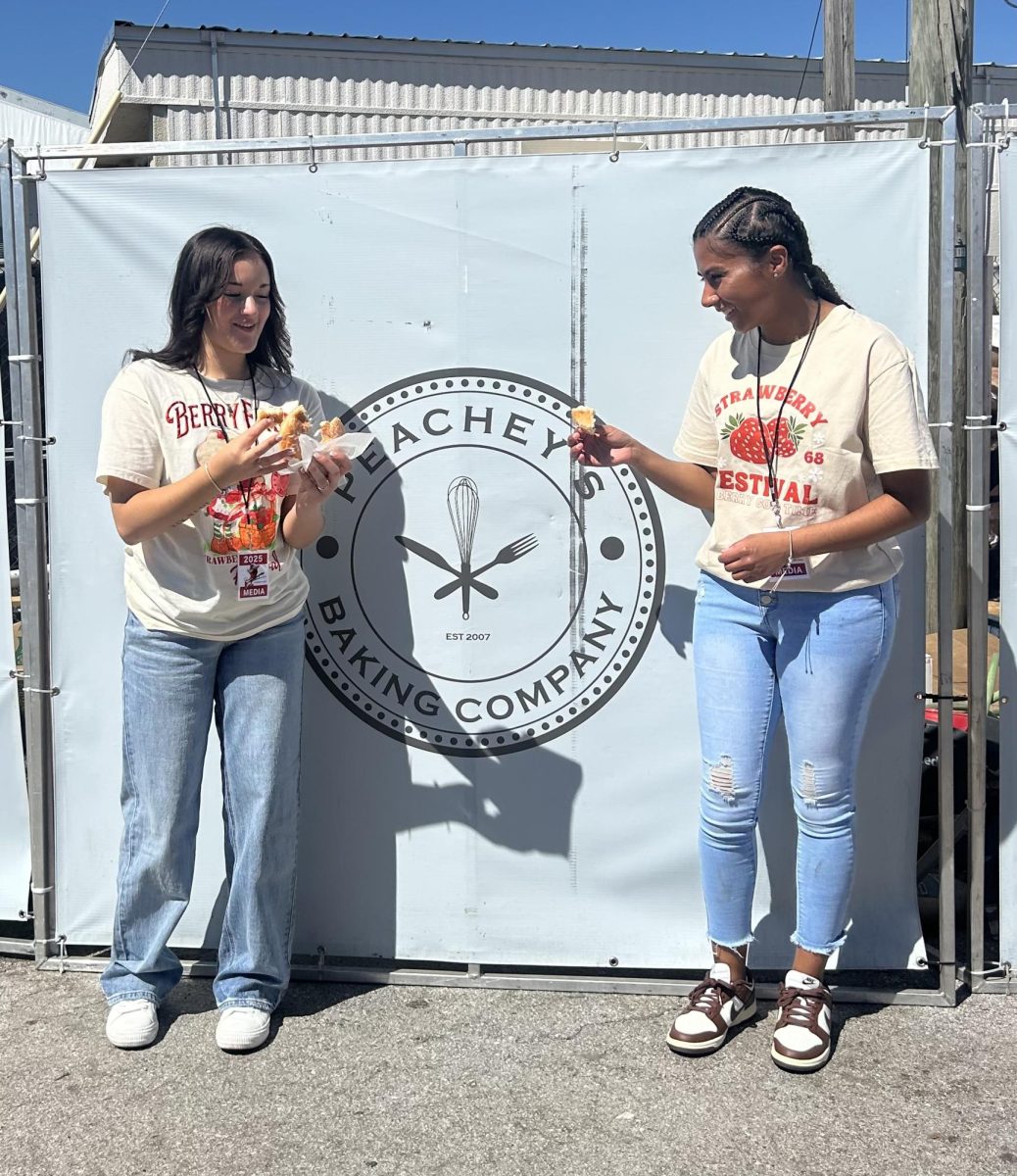 Seniors Brianna Ruel and Margarita Munoz prepare to do an interview as they review a glazed donut from Peachey's Baking Company.