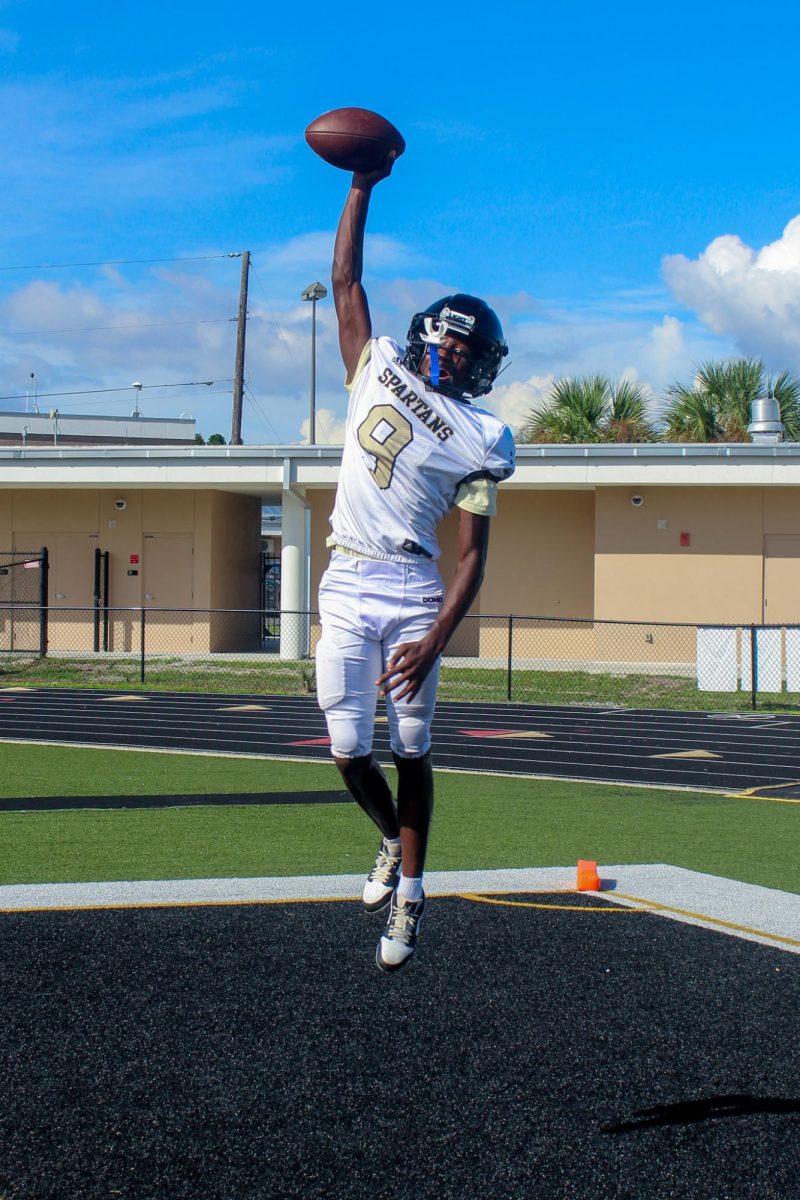 Junior Tyler Nixon jumps up to catch a football being thrown at football practice on the Lakewood High School Football Field, Wednesday, September 10th.