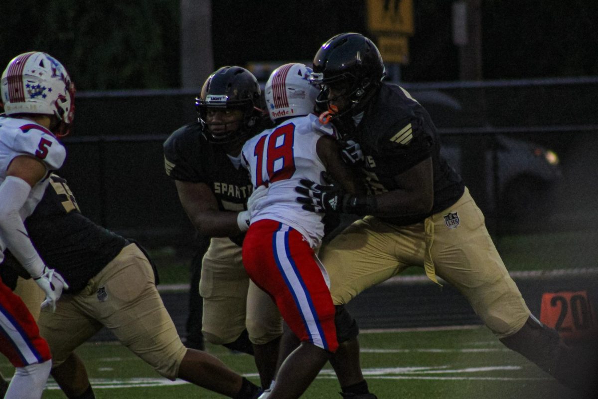 Seniors Chancellor Campbell and Shamel Harris pushes over one of the Pinellas Park players at the 'Glow Out' Football Game.