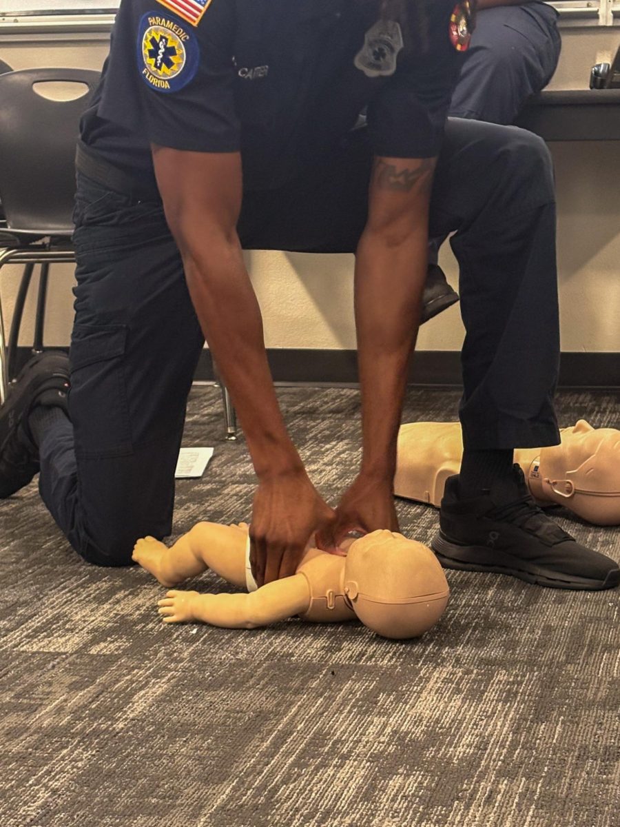 D. Carter demonstrating how to perform CPR on a baby mannequin to a class of students in Ms. Milner's Classroom at Lakewood High School on Jan 23.