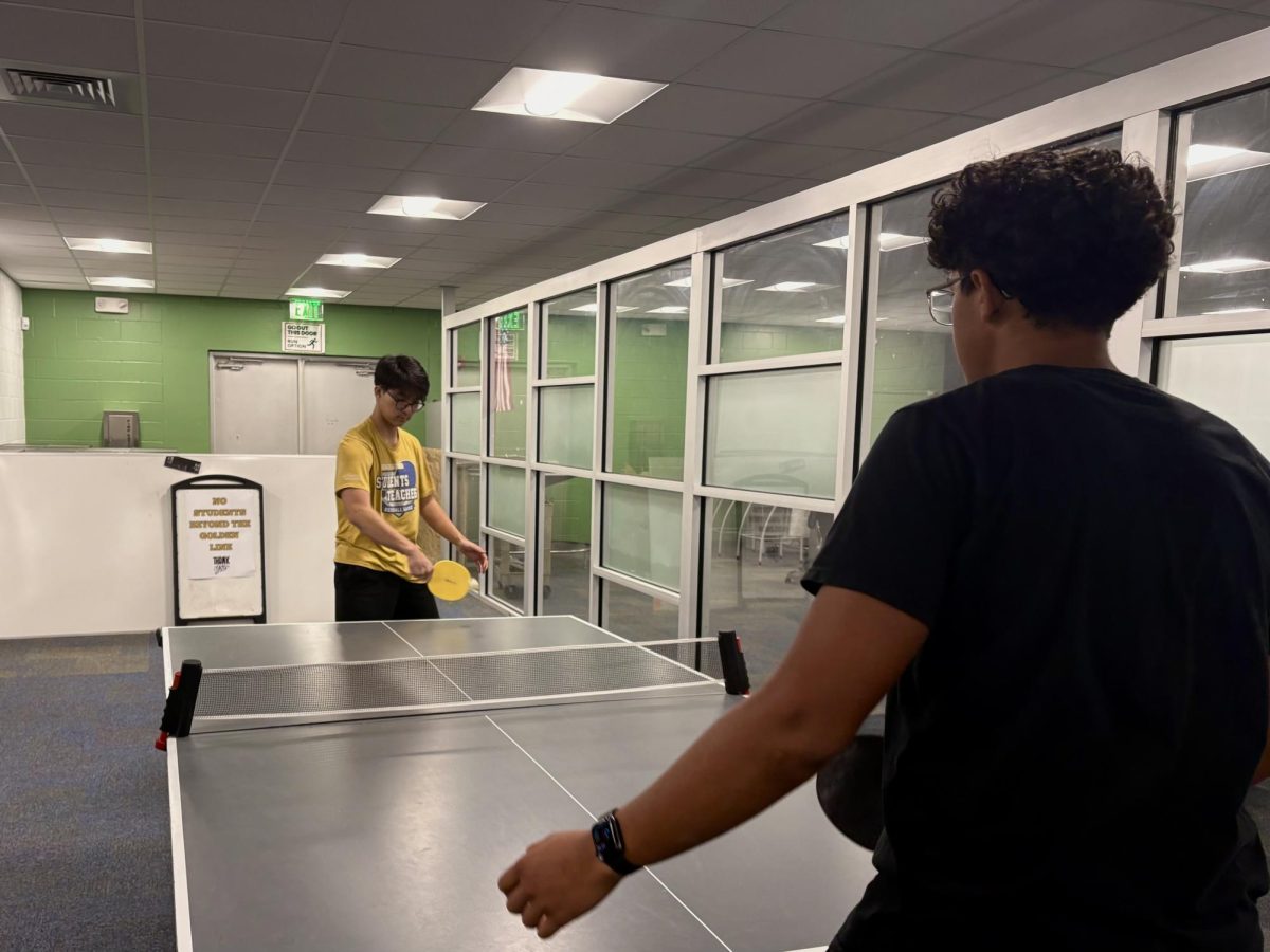 Junior Thompson Tran plays a match of Table Tennis against Junior Elijah Molina-Cruz in Lakewood High School's Media Center on March 25. “It’s a way to hangout with friends,” Molina Cruz said. 